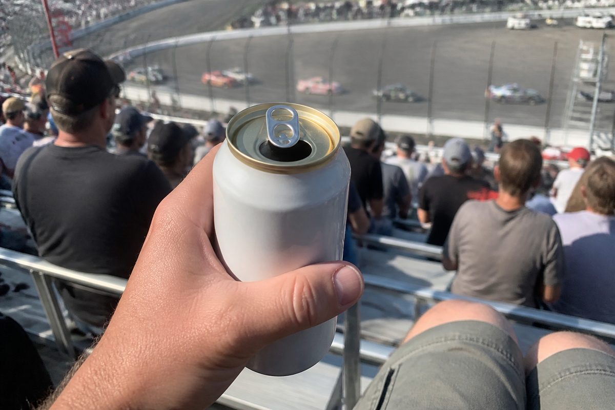 Opened beer can held in direct sunlight in the grandstands